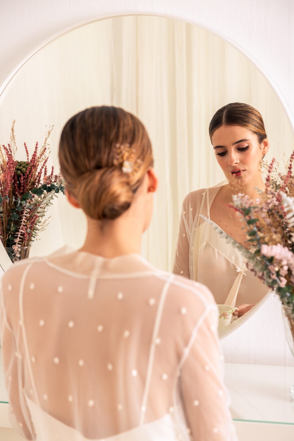 Bride in the Celine dotted tulle robe, seen from behind at the mirror