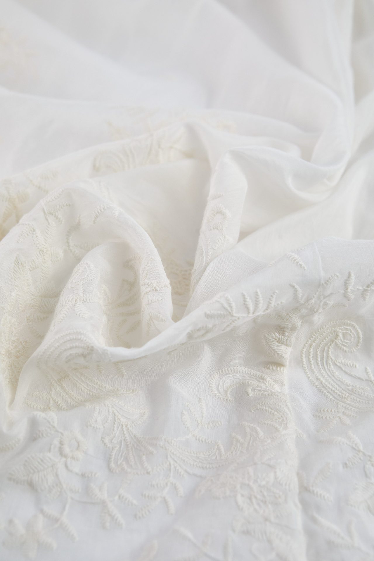 Close-up of the white embroidered fabric of the Alma bridal robe