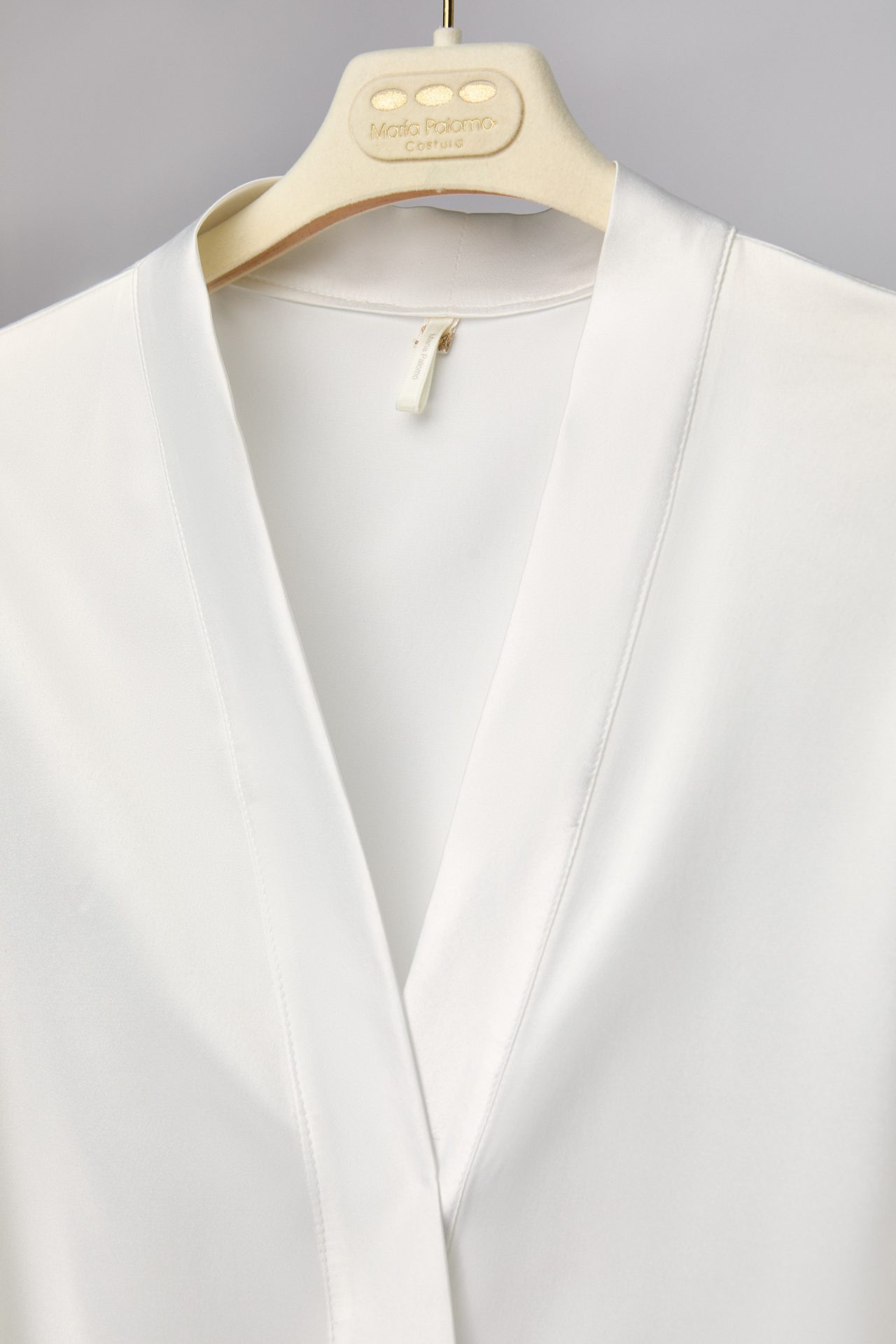 Wrap neckline of the Lola bridal robe on its hanger