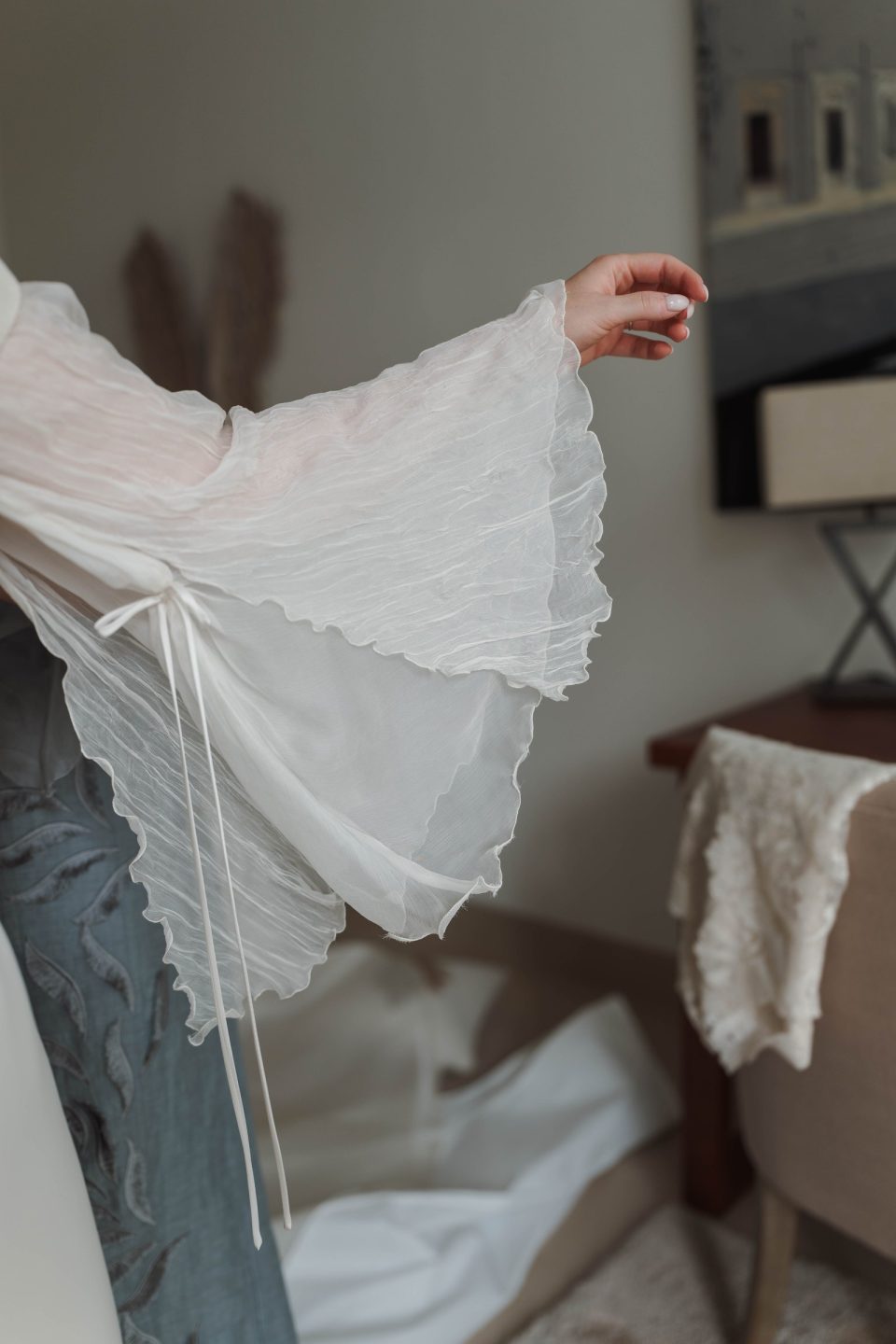 Detalle de las mangas desmontables de doble tejido de seda del vestido de novia, unidas por dentro con un lazo