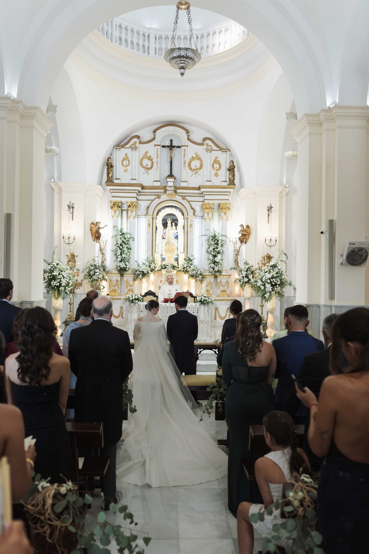 Inmaculada de espaldas en el altar del Santuario de Nuestra Señora de Gracia, con la cola de gazar de seda de su vestido de novia extendida por el pasillo