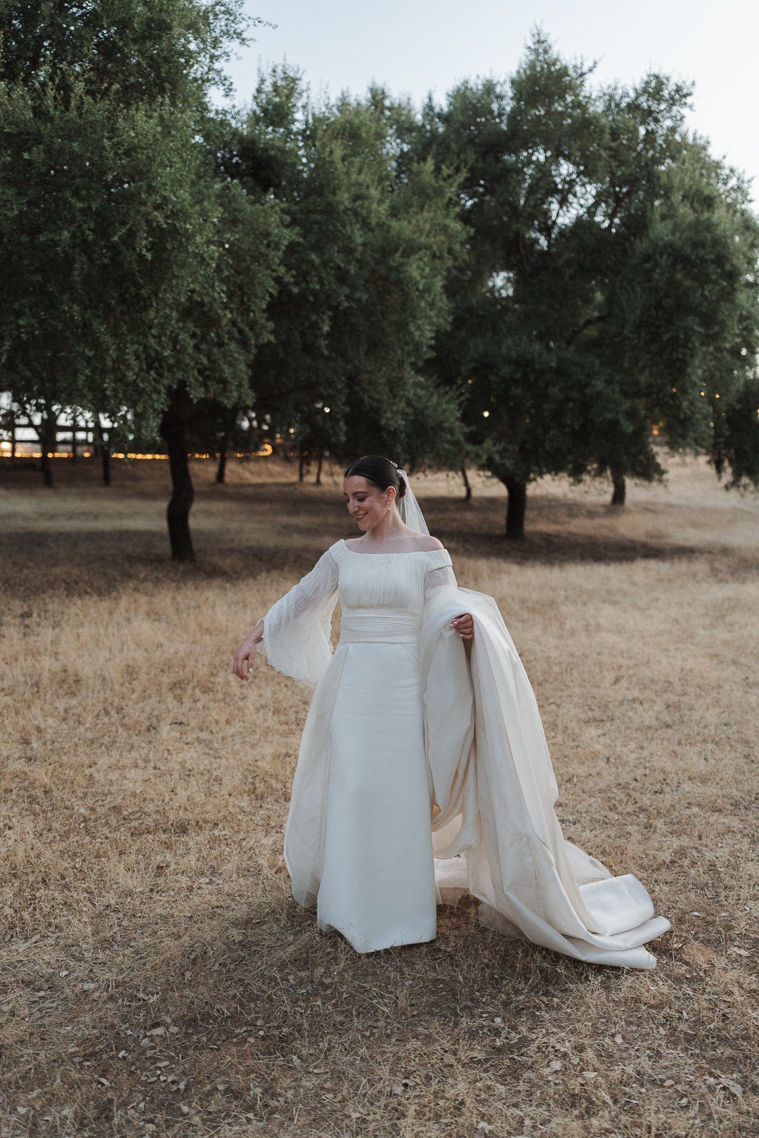 Inmaculada en el cóctel, entre olivos, con la sobrefalda de seda rústica de su vestido de novia